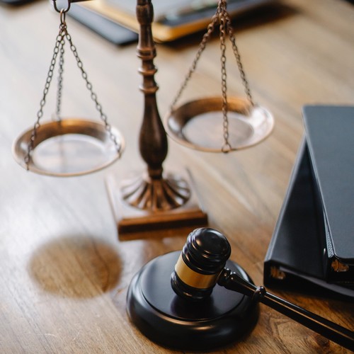 Une balance et un marteau de juge sont posés sur une table en bois